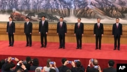 FILE - New members of the Politburo Standing Committee, from left, Han Zheng, Wang Huning, Li Zhanshu, Xi Jinping, Li Keqiang, Wang Yang, Zhao Leji stand together on Oct. 25, 2017, the day after the end of the 19th Communist Party Congress. 