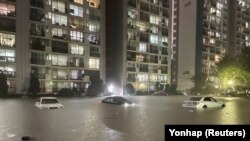 Vehicles get partly submerged at a flooded parking lot during heavy rain in Seoul, South Korea, on August 8, 2022. 