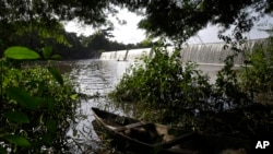 A fishing canoe sits near a dam that sources the sacred Osun River in Esa-Odo, Nigeria, on May 28, 2022.