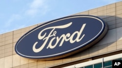 FILE - The Ford logo is seen on the automaker's headquarters in Dearborn, Mich. 