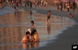 FILE - Palestinians spend time at the beach along the Mediterranean Sea in Gaza City, Aug. 14, 2022.