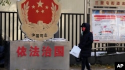 一名北京居民走過三里河街道普法宣傳欄。（2021年11月8日）