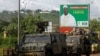 FILE - A convoy of peace keeping forces stand next to an electoral billboard of Soumaila Cisse, leader of URD (Union for the Republic and Democracy) opposition party during a patrol in Bamako, Mali, Aug. 9, 2018. 