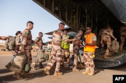 File - French soldiers board a plane in Gao, amid the French military drawdown with troops leaving the last bases in Mali, June 28, 2022.