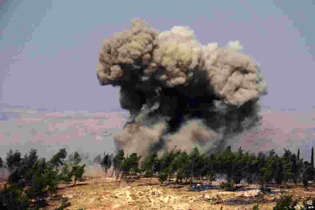 Smoke billows at the site of a reported Russian strike in a forest area west of in Syria&#39;s rebel-held northwestern city of Idlib. (Photo by Muhammad HAJ KADOUR / AFP)