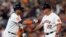 Yuli Gurriel (izquierda) de los Astros de Houston saluda al coach de primera base Omar López (22) tras batear un sencillo remolcador ante los Medias Rojas de Boston, el 2 de agosto de 2022. 