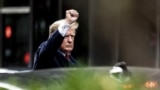 El expresidente Donald Trump hace un gesto al salir de la Torre Trump, el miércoles 10 de agosto de 2022, en Nueva York, de camino a la oficina del fiscal general de Nueva York para una declaración en una investigación civil. (Foto AP/Julia Nikhinson)