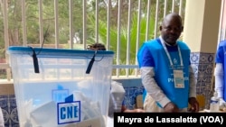 Delegado de mesa olha para urna com os boletins de voto na assembleia de voto da Escola São José de Cluny