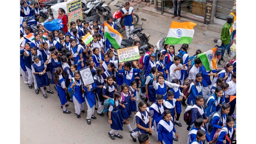 Anak-anak sekolah berjalan mengibarkan bendera nasional menjelang Hari Kemerdekaan India di Prayagraj, di negara bagian Uttar Pradesh, India utara, Rabu, 10 Agustus 2022. (Foto: AP)