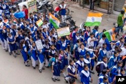 Anak-anak sekolah berjalan mengibarkan bendera nasional menjelang Hari Kemerdekaan India di Prayagraj, di negara bagian Uttar Pradesh, India utara, Rabu, 10 Agustus 2022. (Foto: AP)