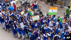 Schoolchildren walk waving the national flag ahead of India's Independence Day in Prayagraj, in northern Indian state of Uttar Pradesh, Wednesday, Aug 10, 2022. India will celebrate its 75th Independence Day anniversary on Aug. 15.