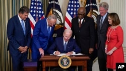 President Joe Biden signs the Democrats' landmark climate change and health care bill in the State Dining Room of the White House in Washington, Aug. 16, 2022.