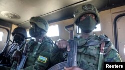 FILE - Soldiers from the Rwandan security forces sit inside an Armored Personal Carrier near the Afungi natural gas site, Mozambique, Sept. 22, 2021. 