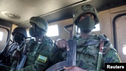 FILE - Soldiers from the Rwandan security forces sit inside an Armored Personal Carrier (APC) near the Afungi natural gas site, Mozambique, Sept. 22, 2021. 