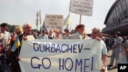 FILE - A group of several hundred, some carrying banners in English, demonstrate for Ukrainian sovereignty at the Kyiv airport on, July 5, 1991, when President Mikhail Gorbachev was on hand to meet German Chancellor Helmut Kohl. Ukraine gained its independence later in the year.