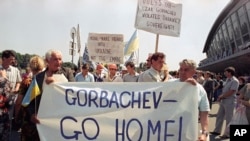 Ratusan warga Ukraina memegang spanduk yang berisi tulisan mengusir pemimpin Uni Soviet pada saat itu, Mikhail Gorbachev dalam aksi demo di Bandara Kyiv, pada 5 Juli 1991, ketika Gorbachev akan bertemu dengan Kanselir Jerman pada saat itu Helmut Kohl. (Foto: AP/Efrem Lukatsky)