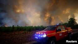 Petugas pemadam kebakaran berupaya memadamkan api di Belin-Beliet, saat kebakaran hutan terus meluas di wilayah Gironde, Prancis barat daya, 10 Agustus 2022. (REUTERS/Stephane Mahe)