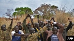 Des soldats stagiaires pour une nouvelle armée unifiée lèvent les mains jointes alors qu'ils assistent à un programme de réconciliation organisé par la Mission des Nations Unies au Soudan du Sud (MINUSS) dans une caserne de fortune à Mapel, le 31 janvier 2020.