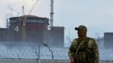 Un militar con una bandera rusa en su uniforme hace guardia cerca de la planta de energía nuclear de Zaporizhzhia 