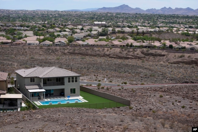 FILE - A home with a swimming pool abuts the desert on the edge of the Las Vegas valley, Wednesday, July 20, 2022, in Henderson, Nevada. (AP Photo/John Locher, File)