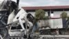 A Thai officer stands beside the burnt down oil tanker at a gas station in Pattani province, southern Thailand, Aug. 17, 2022. 
