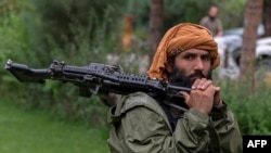 A Taliban fighter stands inside the district center of Bagram in Parwan province, Afghanistan, Aug. 25, 2022.