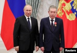 FILE - Russian President Vladimir Putin stands next to Ravil Maganov, of oil producer Lukoil, at the Kremlin in Moscow, Russia, Nov. 21, 2019. (Sputnik/Mikhail Klimentyev/Kremlin via Reuters)