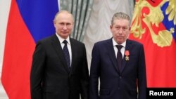 FILE - Russian President Vladimir Putin stands next to Lukoil executive Ravil Maganov after awarding him the Order of Alexander Nevsky during a ceremony at the Kremlin, in Moscow, Russia, Nov. 21, 2019. (Sputnik/Mikhail Klimentyev/Kremlin via Reuters)