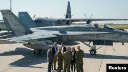 Sekretari i Përgjithshëm i NATO-s, Jens Stoltenberg, duke biseduar me Kryeministrin kanadez Justin Trudeau përpara një avioni CF-18 Hornet të Forcave Ajrore Kanadeze (26 gusht 2022)