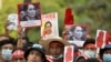 Demonstrators hold placards with pictures of Aung San Suu Kyi as they protest against the military coup in Yangon, Burma. (File)