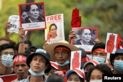 Demonstran memegang plakat bergambar Aung San Suu Kyi saat memprotes kudeta militer di Yangon, Myanmar, 22 Februari 2021. (Foto: Reuters)