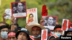 Demonstrators hold placards with pictures of Aung San Suu Kyi as they protest against the military coup in Yangon, Burma. (File)