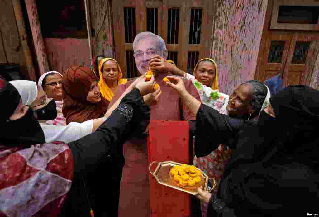 Muslim women offer sweets to a cardboard cut-out of Indian Prime Minister Narendra Modi to celebrate on the eve of the Hindu festival of Raksha Bandhan in Ahmedabad.