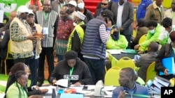 FILE - The Electoral Commission (IEBC) Chairman, Wafula Chebukati, middle in red shirt, and IEBC commissioners at the National Tallying Centre in Bomas of Kenya, Nairobi, Kenya, Aug. 14, 2022.