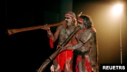 FILE- Two Aboriginal performers painted in traditional colors play the 'Didjiridoo' aboriginal instrument at the 'Festival of the Dreaming' in Sydney. Some events will showcase Indigenous languages and traditional dance steps not seen by non-Aboriginal people in nearly 200 years.