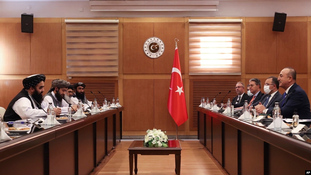 FILE - Turkish Foreign Minister Mevlut Cavusoglu, right, and Amir Khan Muttaqi, the acting foreign minister, of Afghanistan, left, speak during a meeting, in Ankara, Turkey, Thursday, Oct. 14, 2021. 