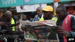 Motorcycle riders read The Standard, a local daily newspaper, with a headline reporting the election of Kenya's 5th President elect William Ruto, in Eldoret, Aug. 16, 2022. 