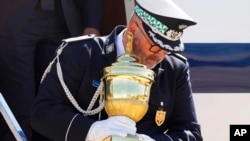 Un militar portugués baja del avión sosteniendo el relicario con el corazón del emperador Pedro I en Brasilia, el 22 de agosto del 2022. 