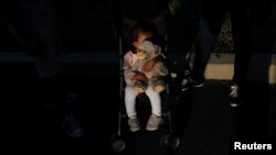 Evangeline, de 1 año, sostiene a su osito después de que sus padres, Juan Camilo Mendoza y Noralis Zuniga, la subieran a su cochecito afuera del Mary's Center en Washington, EEUU, el 23 de agosto de 2022.