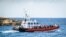 FILE - Migrants aboard a Guradia di Finanza and Navy military vessel are transferred from an operational processing facility on the southern Italian Island of Lampedusa, south of Sicily, to another center, on July 11, 2022.