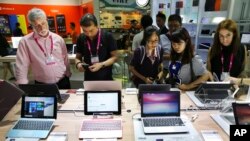 FILE - Visitors review new Asus computer products at the Computex trade show in Taipei, June 2, 2015.