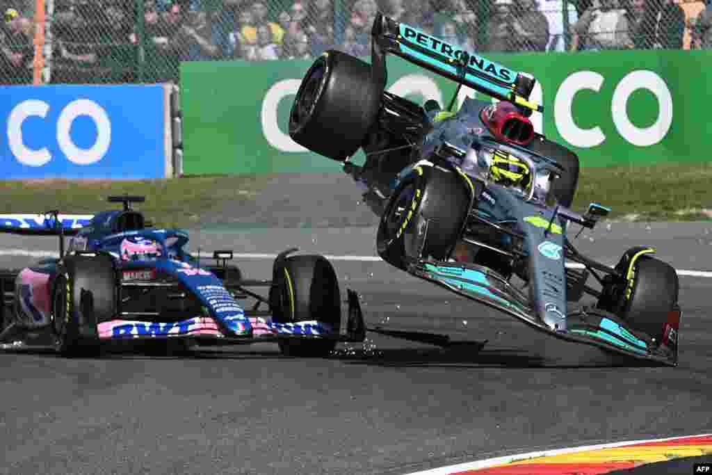Mercedes&#39; British driver Lewis Hamilton (R) collides with Alpine&#39;s Spanish driver Fernando Alonso (C) during the Belgian Formula One Grand Prix at Spa-Francophones racetrack at Spa, Belgium.