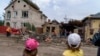 Children watch as workers clean up after a rocket strike on a house in Kramatorsk, Donetsk region, eastern Ukraine, Aug. 12, 2022.