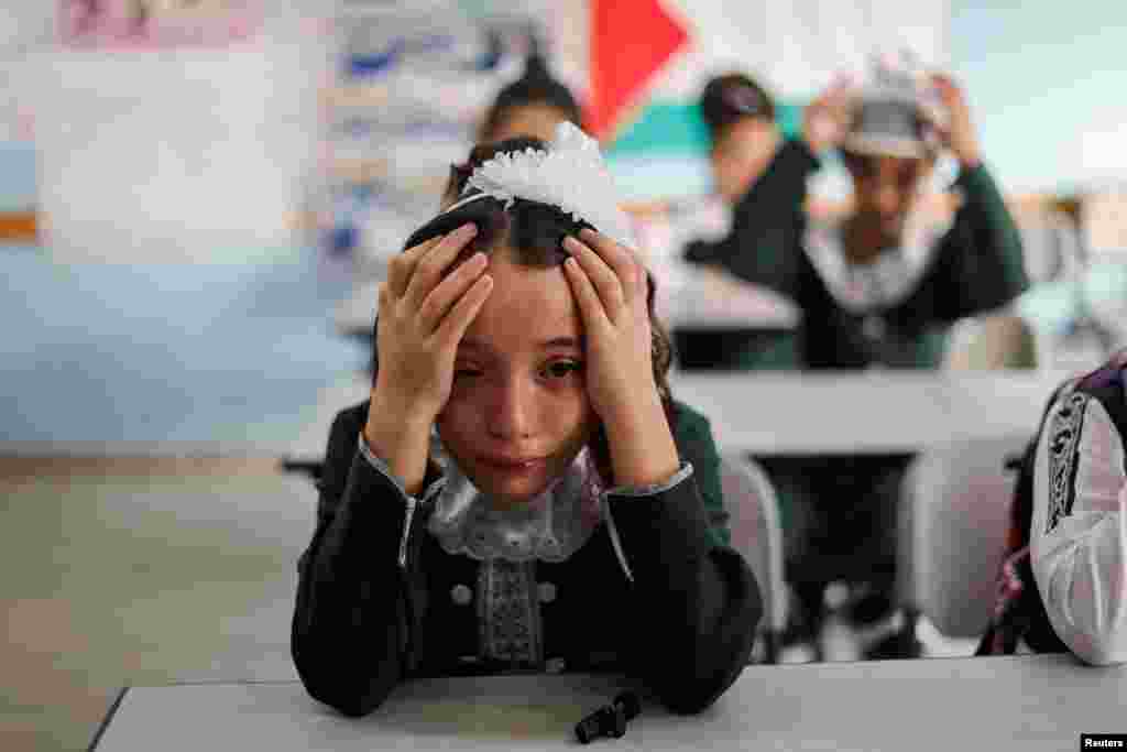 A classmate of Palestinian student Lian Al Shaer, 10, who was killed in recent Israel-Gaza fighting, reacts to Al Shaer&#39;s picture as a new school year begins, in Khan Younis in the southern Gaza Strip.