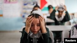 A classmate of Palestinian student Lian Al Shaer, 10, who was killed in recent Israel-Gaza fighting, reacts to Al Shaer&#39;s picture as a new school year begins, in Khan Younis in the southern Gaza Strip.