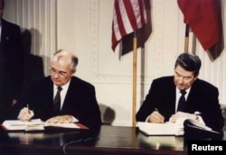 FILE - U.S. President Ronald Reagan, right, and Soviet President Mikhail Gorbachev signing the Intermediate-Range Nuclear Forces treaty at the White House, Washington, on Dec. 8 1987. (REUTERS/Dennis Paquin/File Photo)