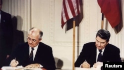 FILE - U.S. President Ronald Reagan, right, and Soviet President Mikhail Gorbachev signing the Intermediate-Range Nuclear Forces treaty at the White House, Washington, on Dec. 8 1987.