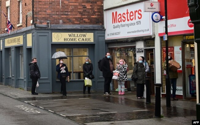 Warga antre di luar kantor pos di Whitchurch, Inggris tengah, 13 Desember 2021, (Paul ELLIS / AFP)