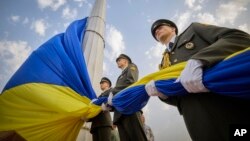 In this photo provided by the Ukrainian Presidential Press Office, honour guard soldiers prepare to rise the Ukrainian national flag during State Flag Day celebrations in Kyiv, Ukraine, Aug. 23, 2022.