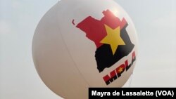 Um jovem carrega um balão com o mapa de Angola e o símbolo e cores do partido MPLA. Camama, Luanda. 